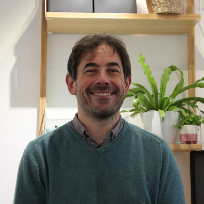 Picture of a man smiling in front of some shelves