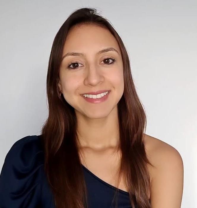 image of a woman standing in front of a wall smiling